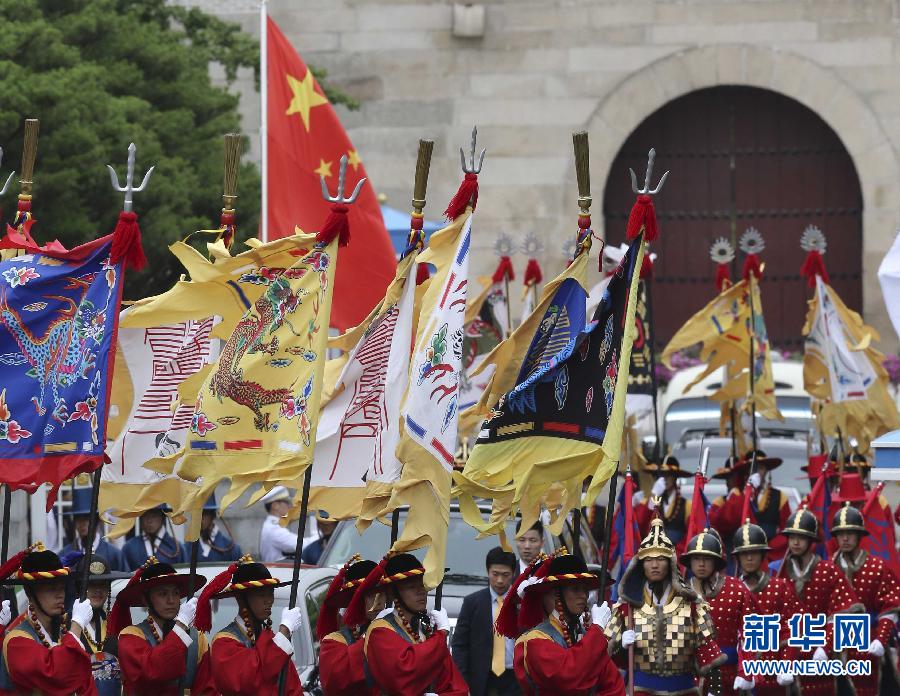 7月3日，韩国总统朴槿惠在青瓦台总统府举行隆重仪式，欢迎中国国家主席习近平对韩国进行国事访问。这是习近平的车队在身着民族服装的韩国礼仪队伍引导下驶入青瓦台。新华社记者丁林摄  